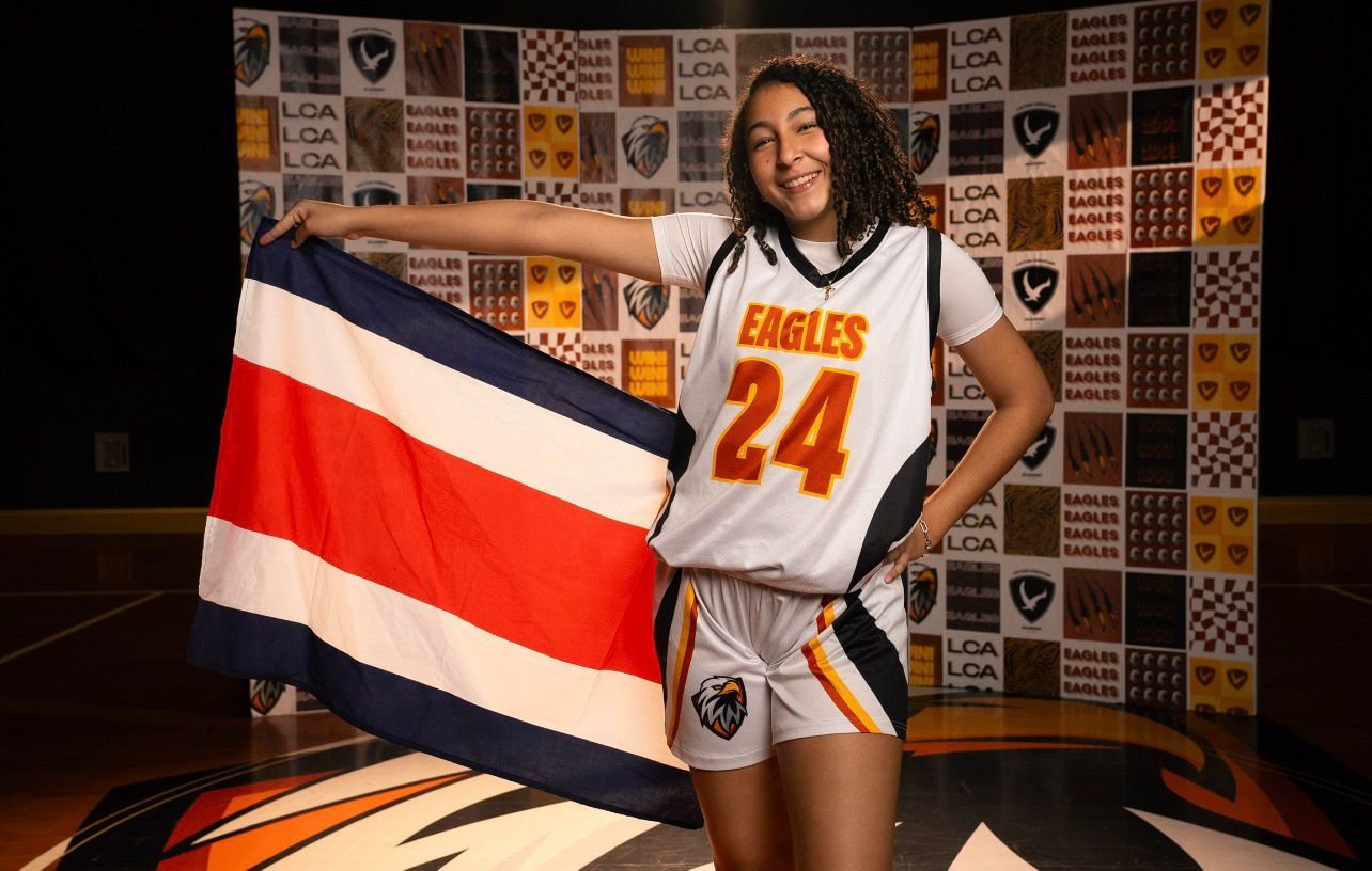 Naima Babb Chaves holding the Costa Rica flag in her Eagles #24 jersey